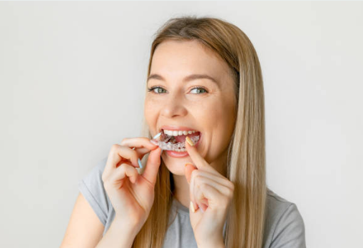 Woman brushing her teeth while wearing braces at home.
